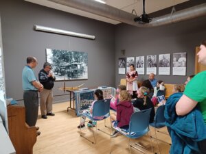 Hmong community members play music for students on traditional instruments