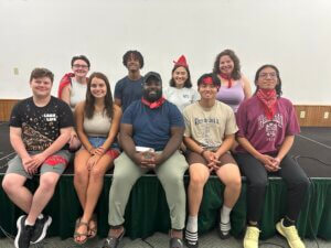 Reg Hawkins poses for photo surrounded by eight student staff members at residence life training.