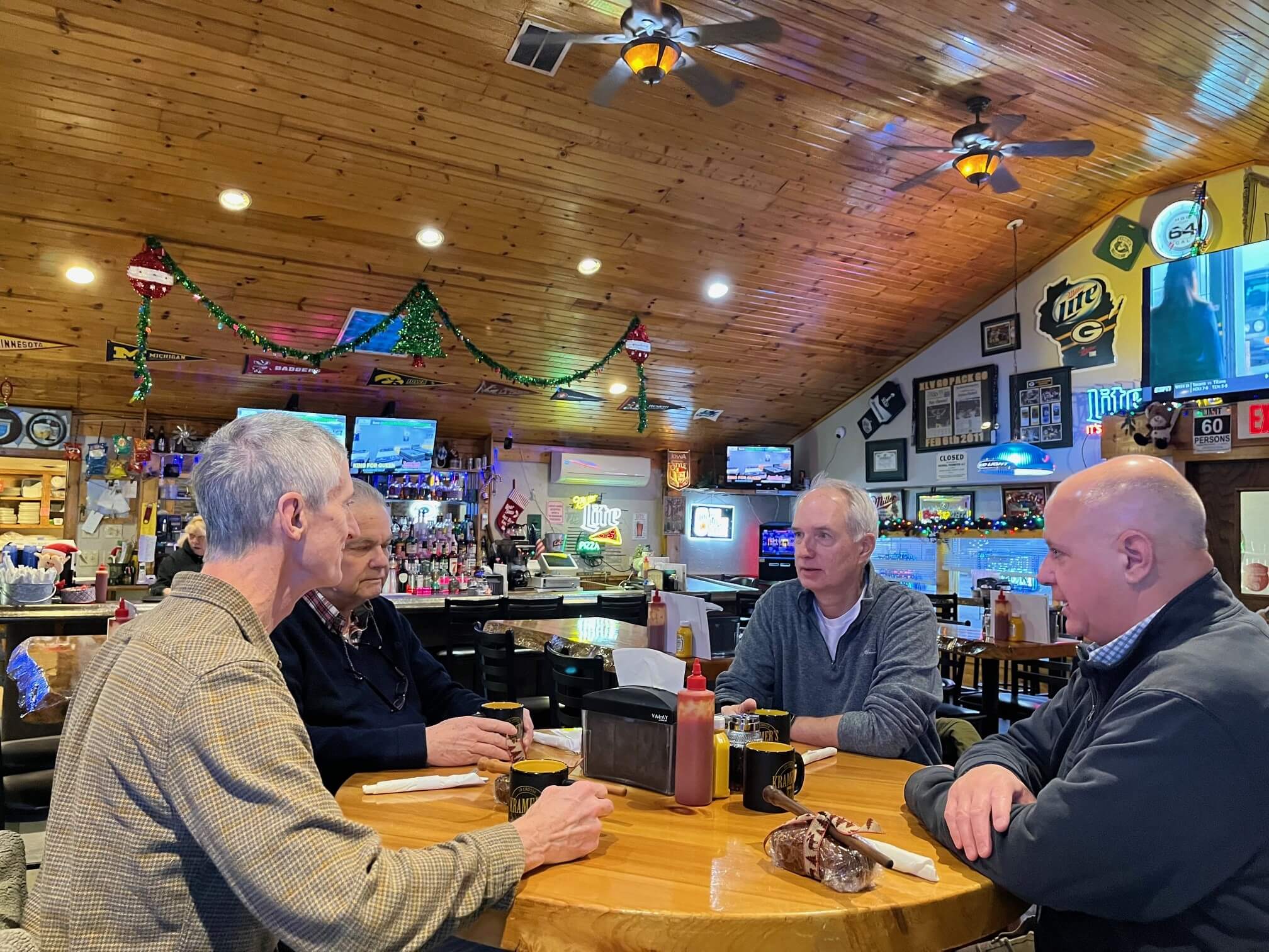 Rick Kyte (third from left) catches up with fellow community members (l-r) Ted Reilly, Tom Thibodeau, and Sam Scinta at one of his "third places," Kramer's Bar and Grill