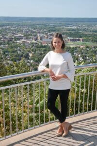 LACF CEO Jamie Schloegel stands at Grandad Bluff with a view of La Crosse behind her.